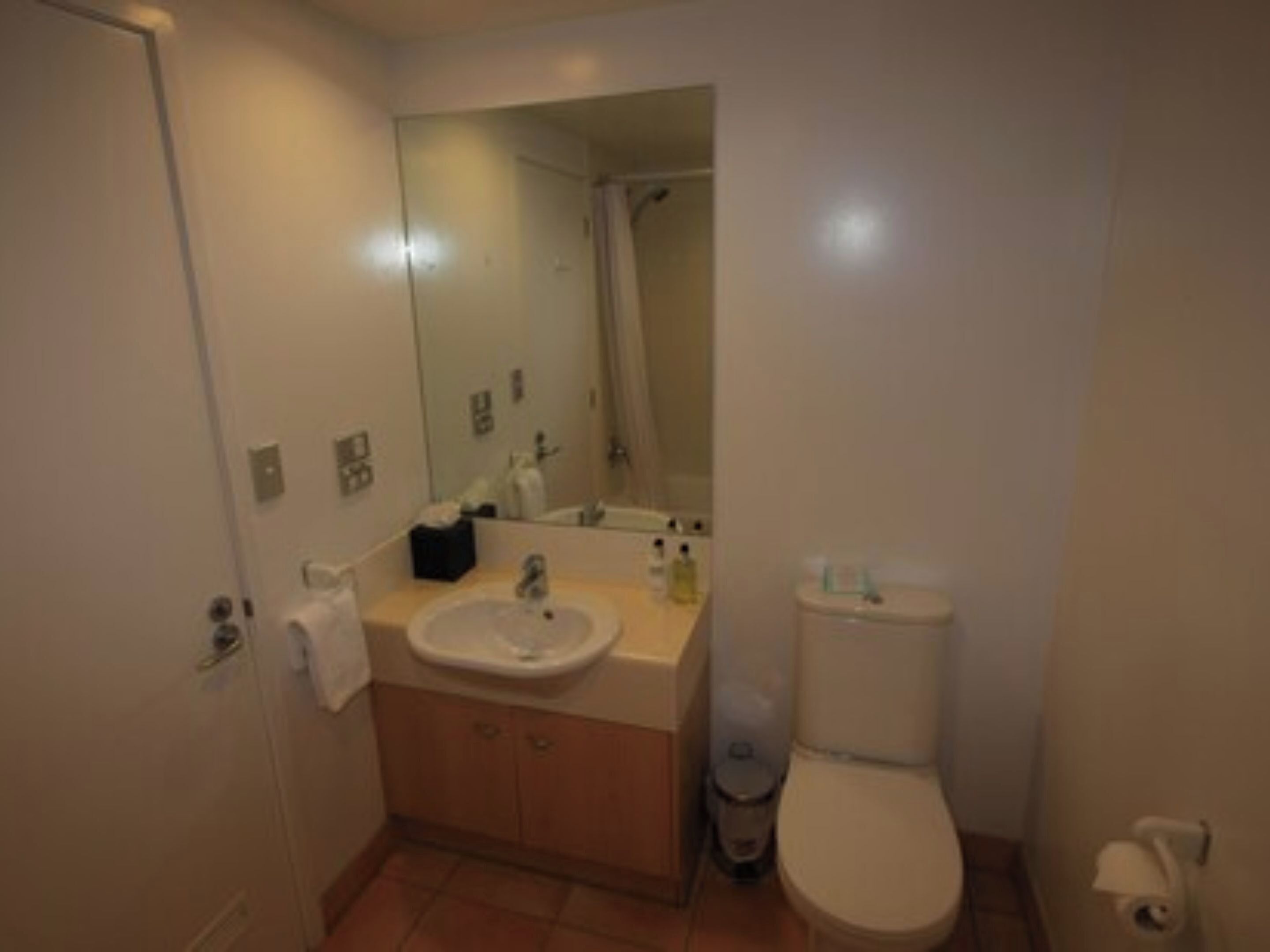 Ein kleines, sauberes Badezimmer mit Waschbecken, Toilette und Spiegel.
