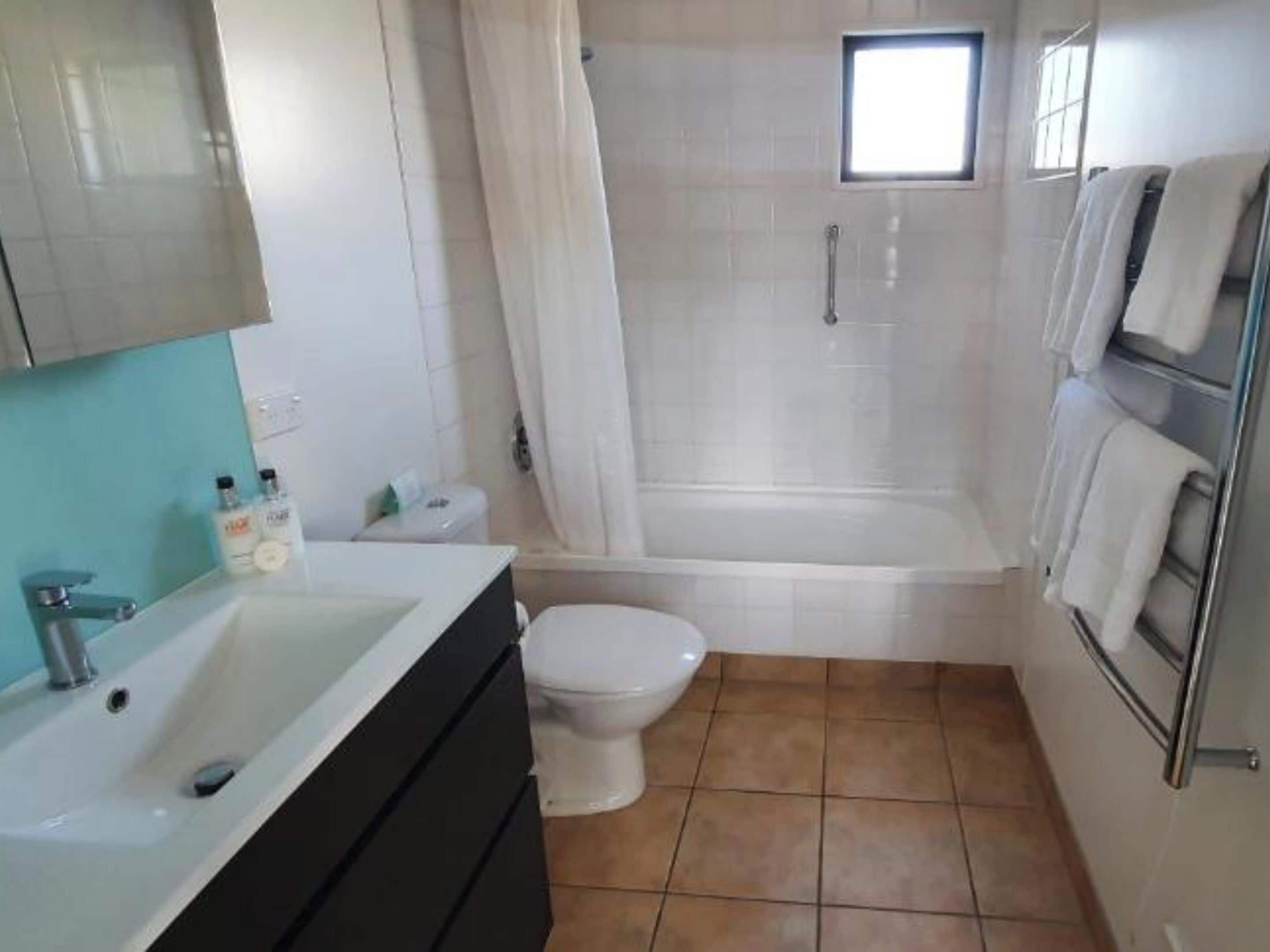 Une salle de bain avec un lavabo, des toilettes et une baignoire.