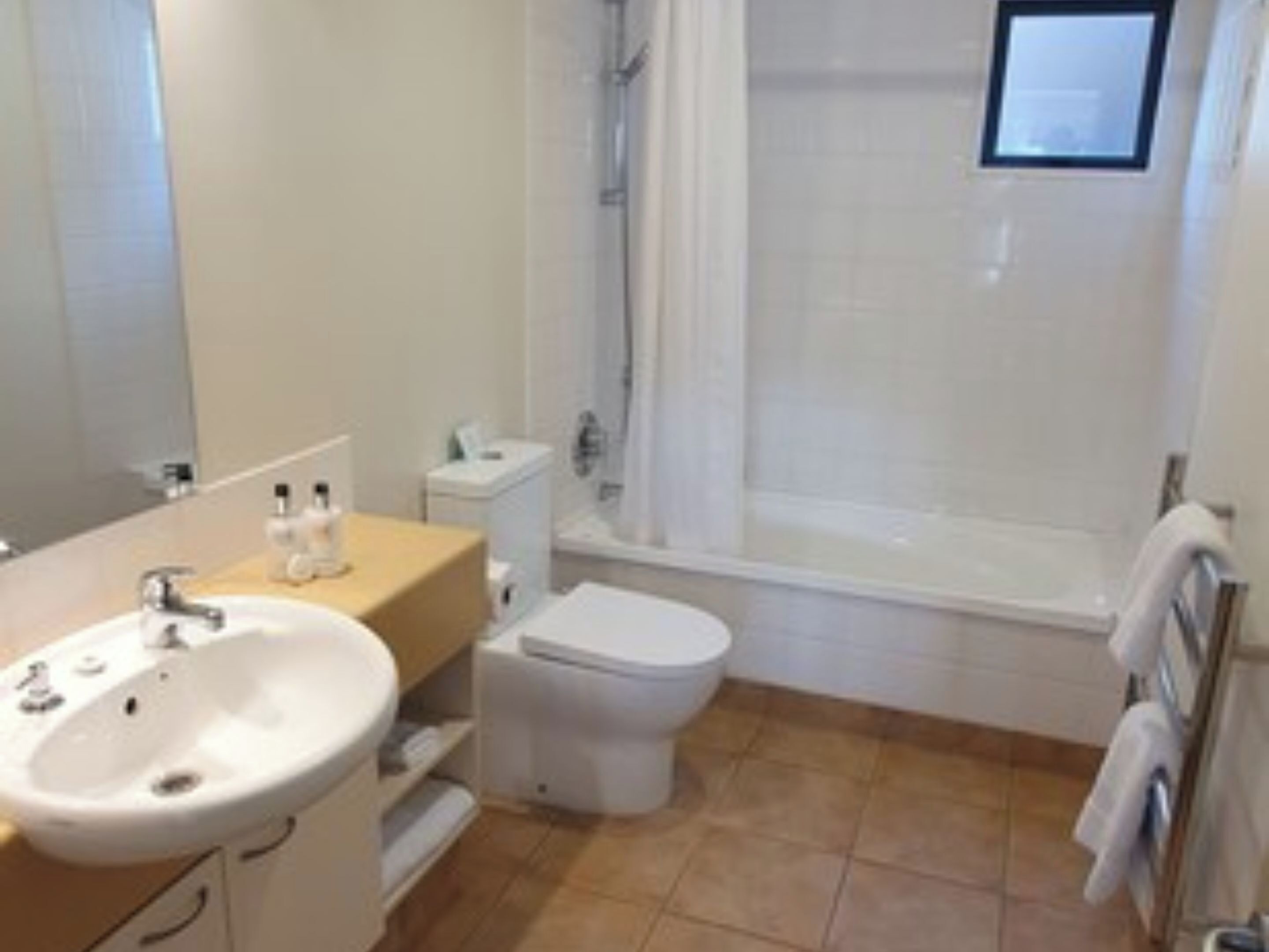 A bathroom with a sink, toilet, and bathtub.