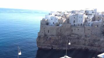 Uma vila costeira com edifícios construídos em um penhasco com vista para o mar.