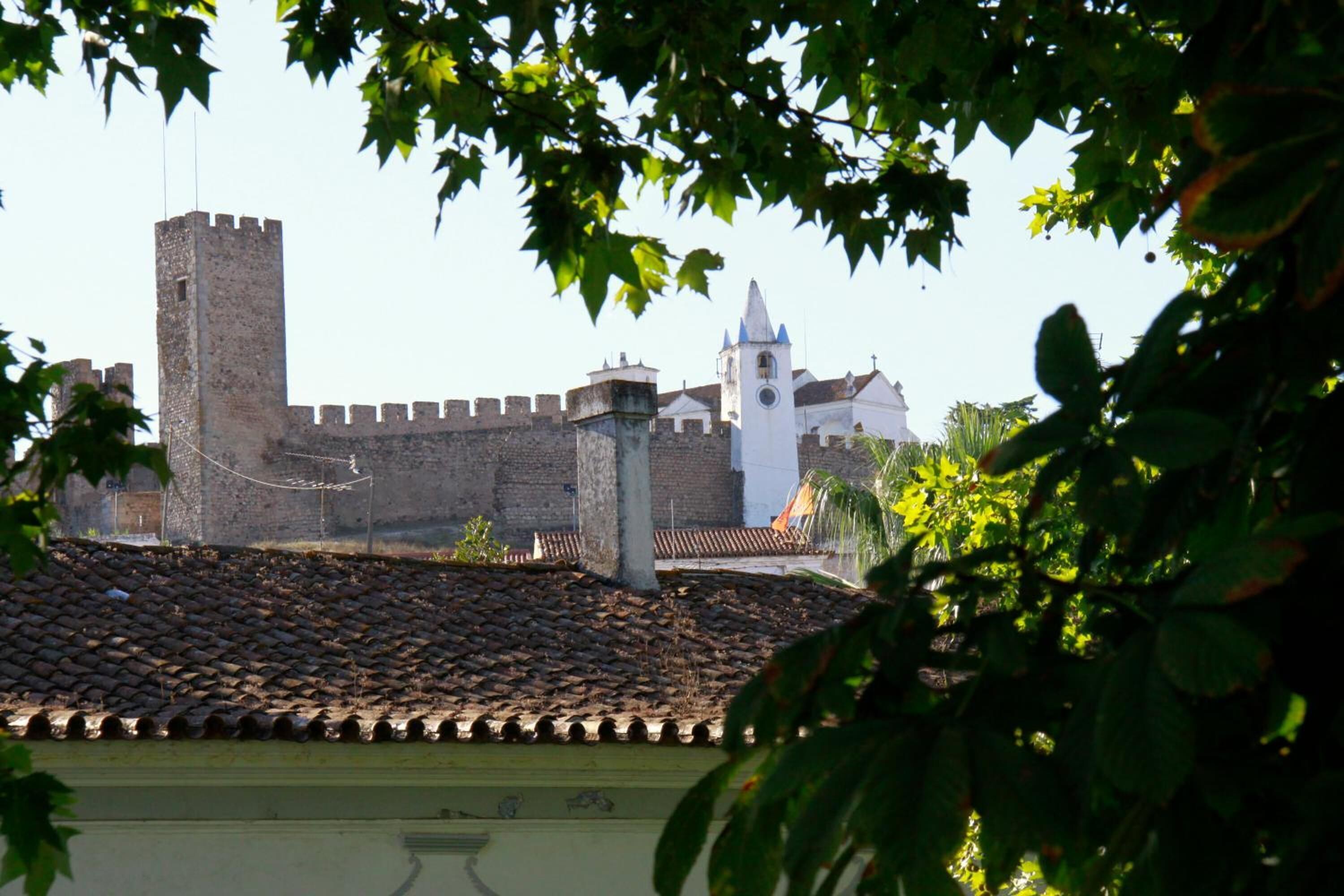 A historic building with a prominent tower and a fortified wall.