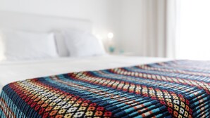 A bed with a colorful, patterned bedspread. - Casa Do Platano (Arraiolos)