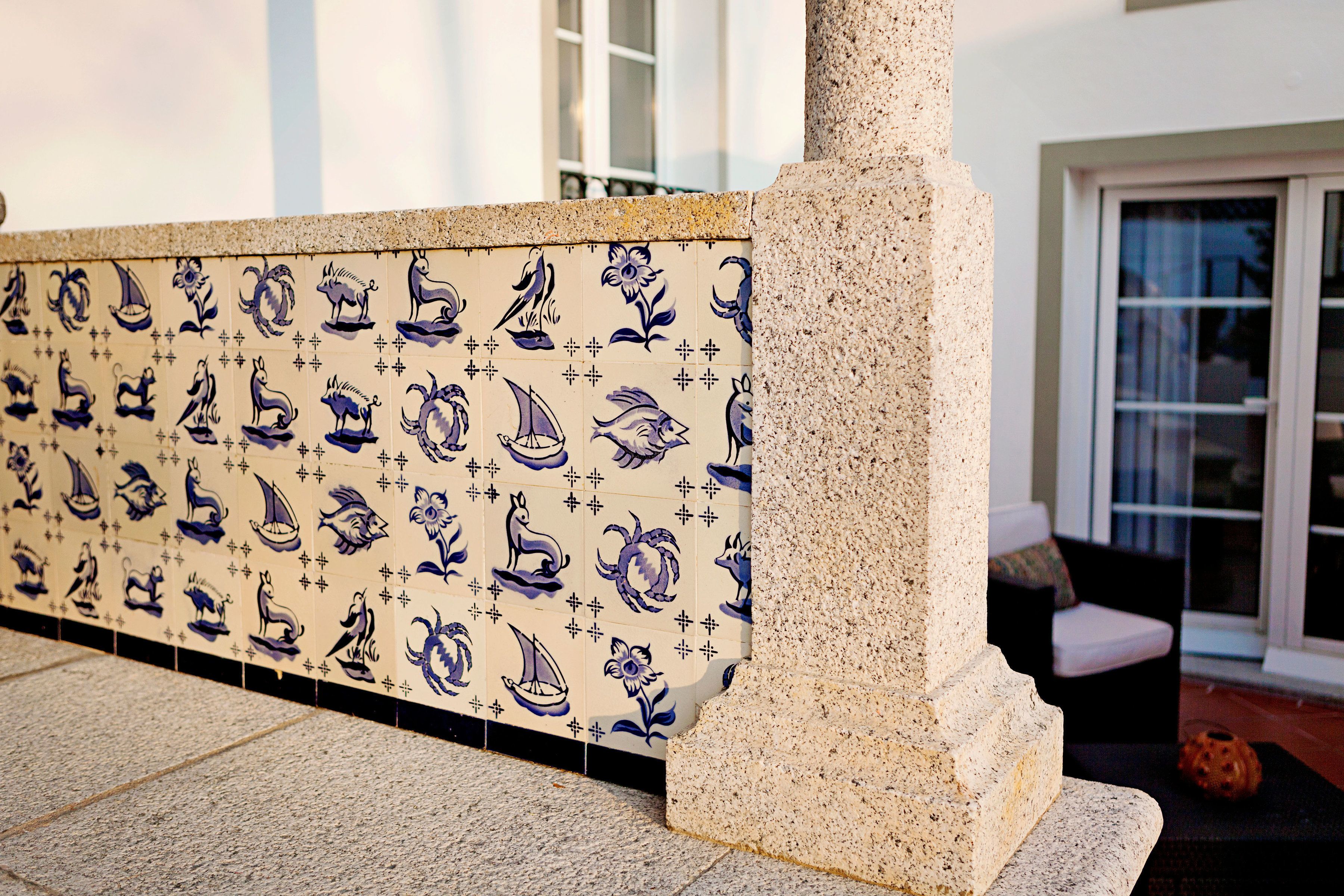 A tiled wall with various animal and ship designs.