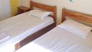 A room with two single beds, wooden headboards, and a large sunflower mural on the wall. - Comfy Hostel Studios (Corfu)