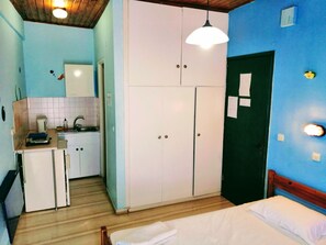 A compact room with a bed, a kitchenette, and a wardrobe. - Comfy Hostel Studios (Corfu)