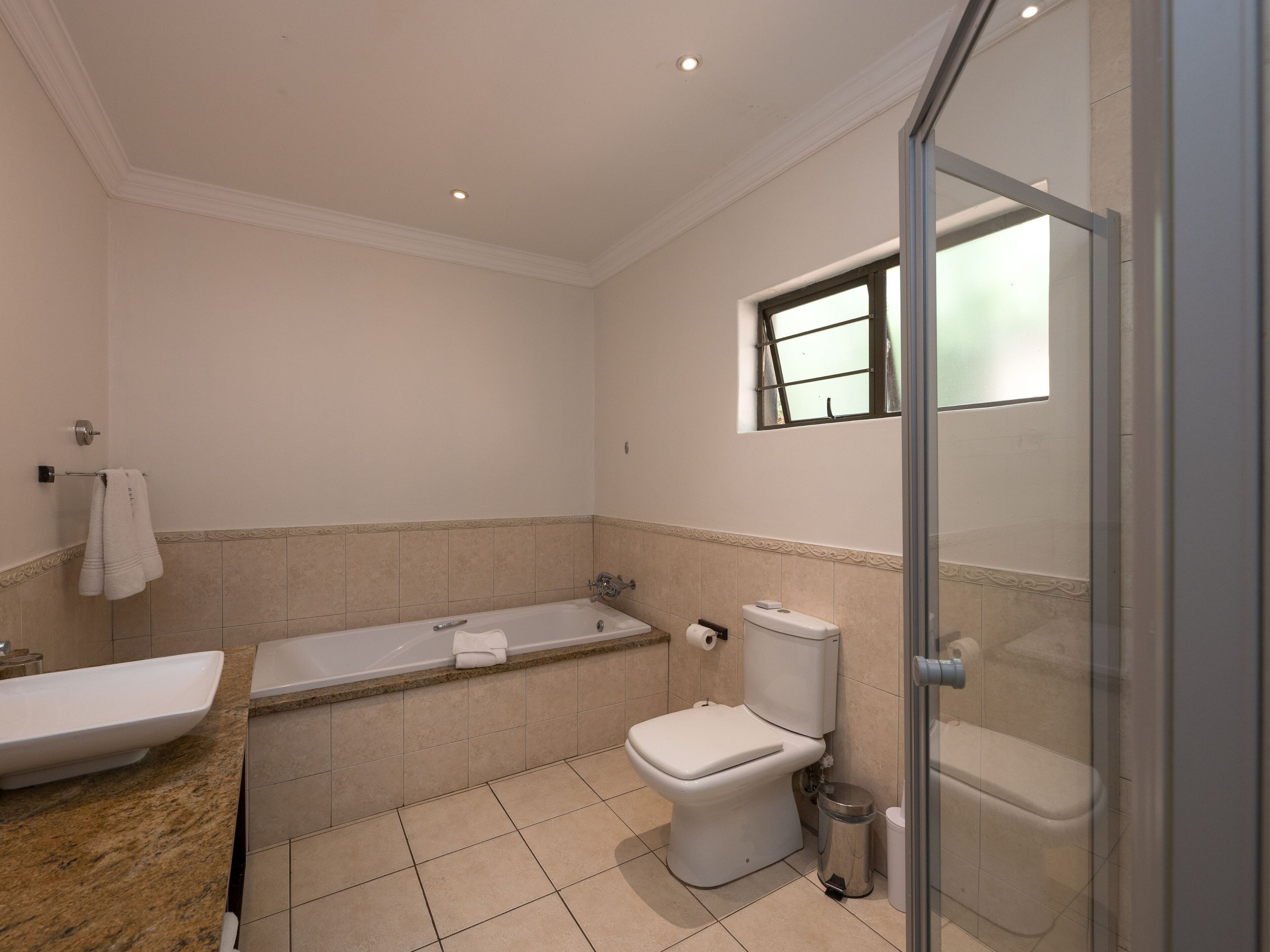 Een badkamer met een bad, toilet en wastafel.