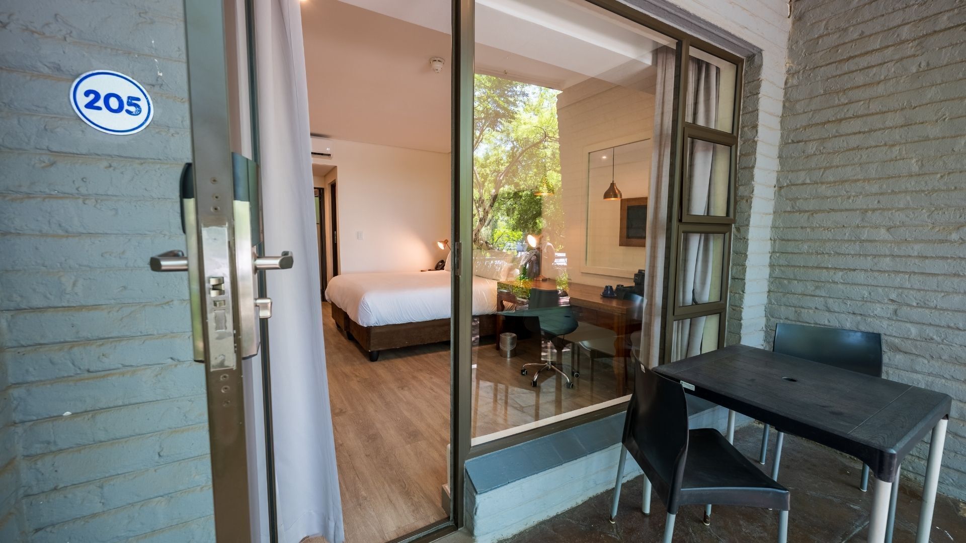A hotel room with a bed, a desk, and a chair.