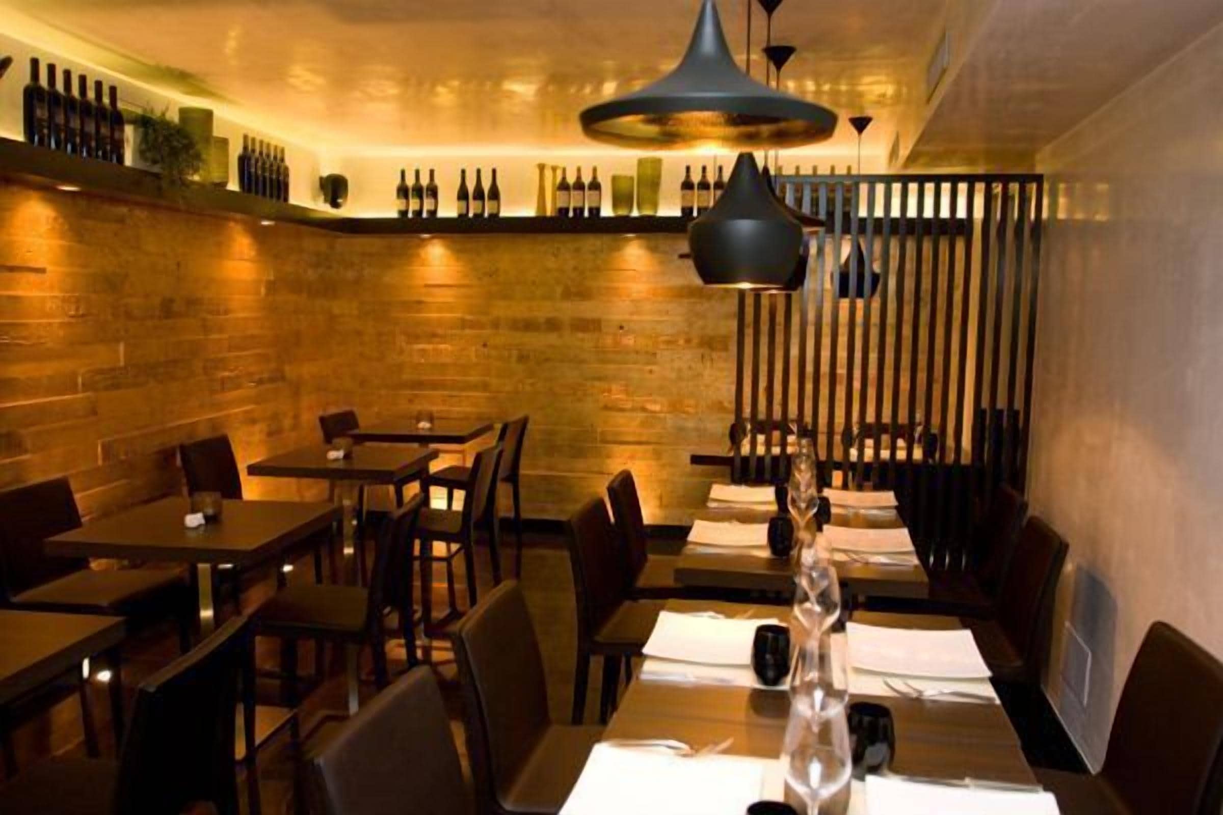 A restaurant with wooden walls, tables, and chairs.