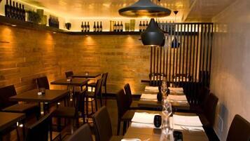 A restaurant with wooden walls, tables, and chairs.
