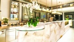 A modern kitchen with a marble countertop, a glass island, and a variety of kitchen appliances.