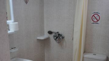 A small bathroom with a shower, toilet, and sink.