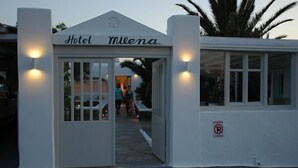 Un edificio blanco con un letrero que dice "Hotel Milena" en la entrada.