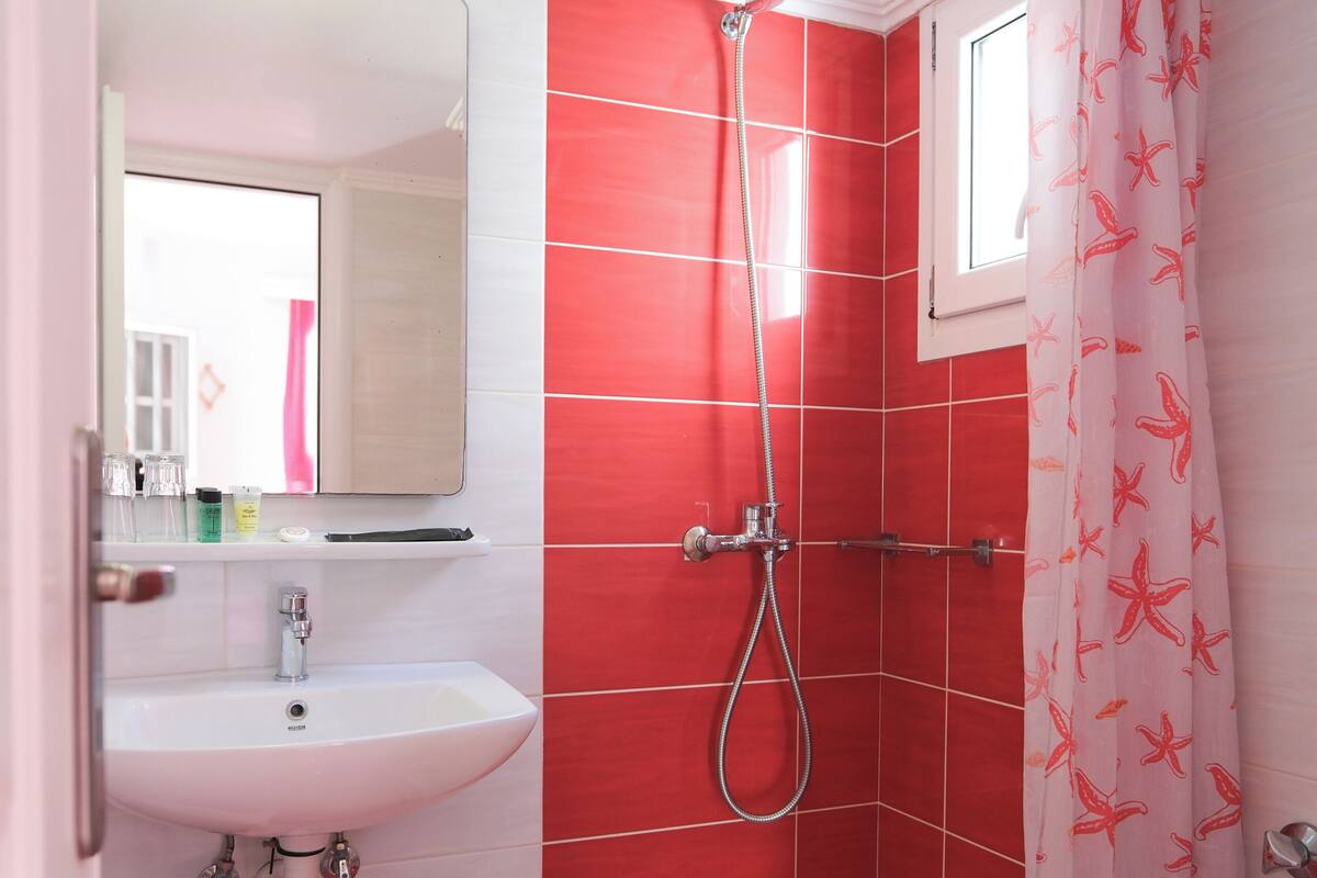 A bathroom with a shower, sink, and toilet.