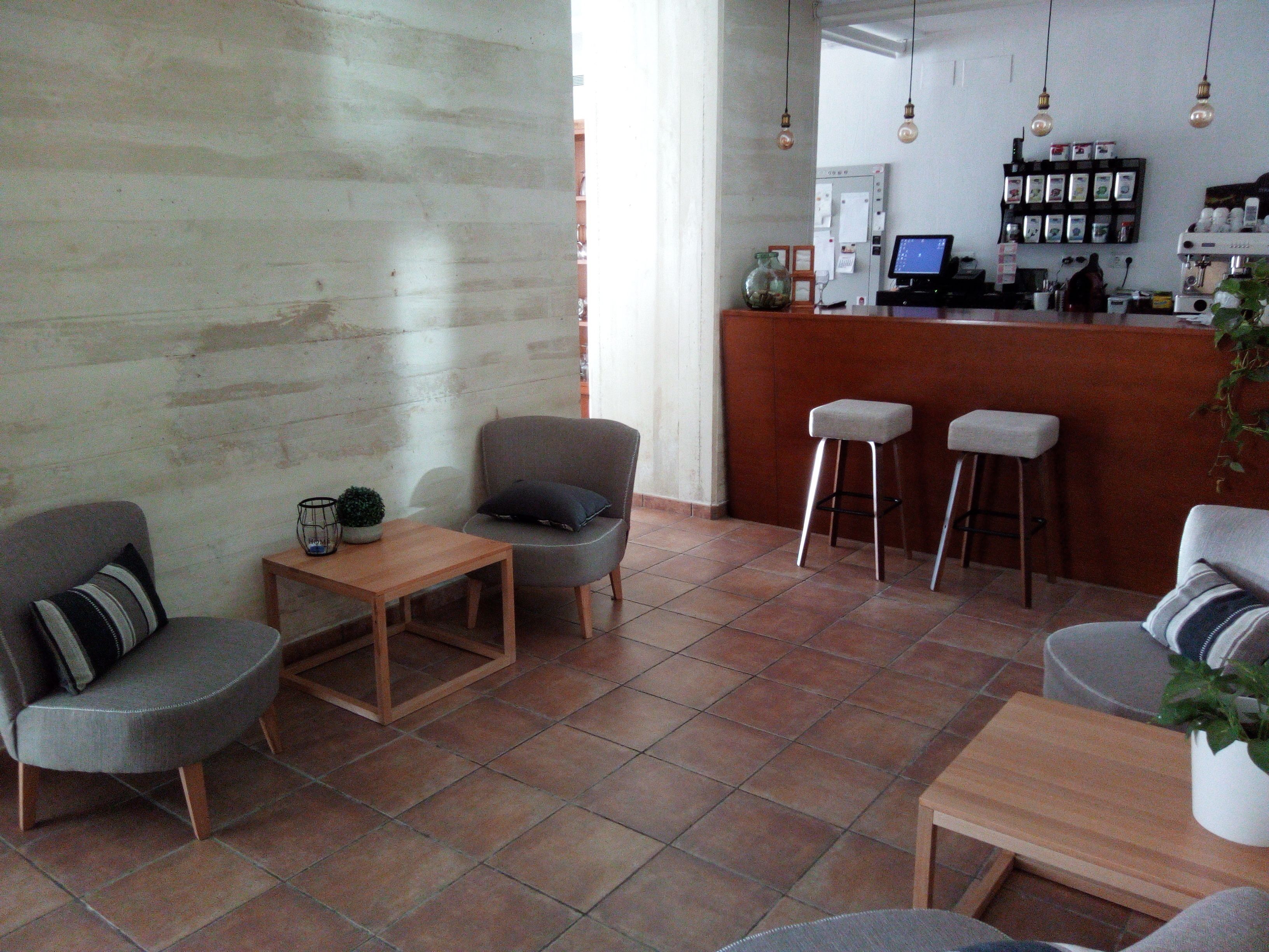 Een modern interieur met een bar, zitgedeelte en een betegelde vloer.