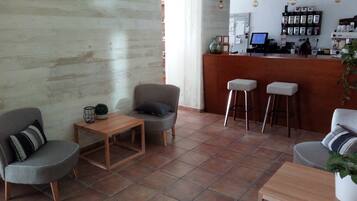 Een modern interieur met een bar, zitgedeelte en een betegelde vloer.