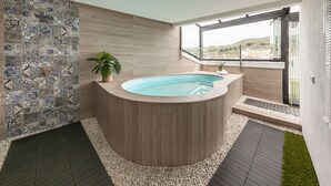 Une salle de bain moderne avec une baignoire sur pieds, un mur recouvert de mosaïques et une vue sur l’extérieur.