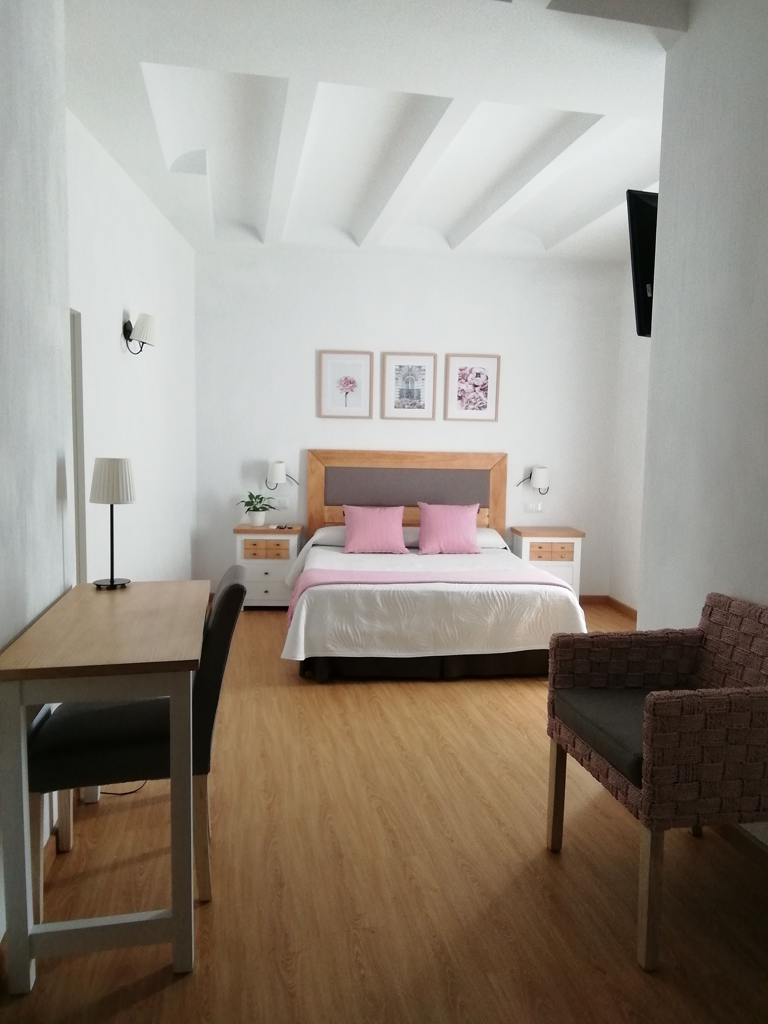 A bedroom with a wooden bed, a desk, and a chair.