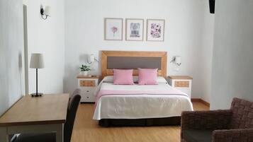 A bedroom with a wooden bed, a desk, and a chair.