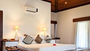 A spacious bedroom with a large bed, wooden flooring, a ceiling fan, and two bedside lamps. - Domus Villas de Luxo (Tibau do Sul)