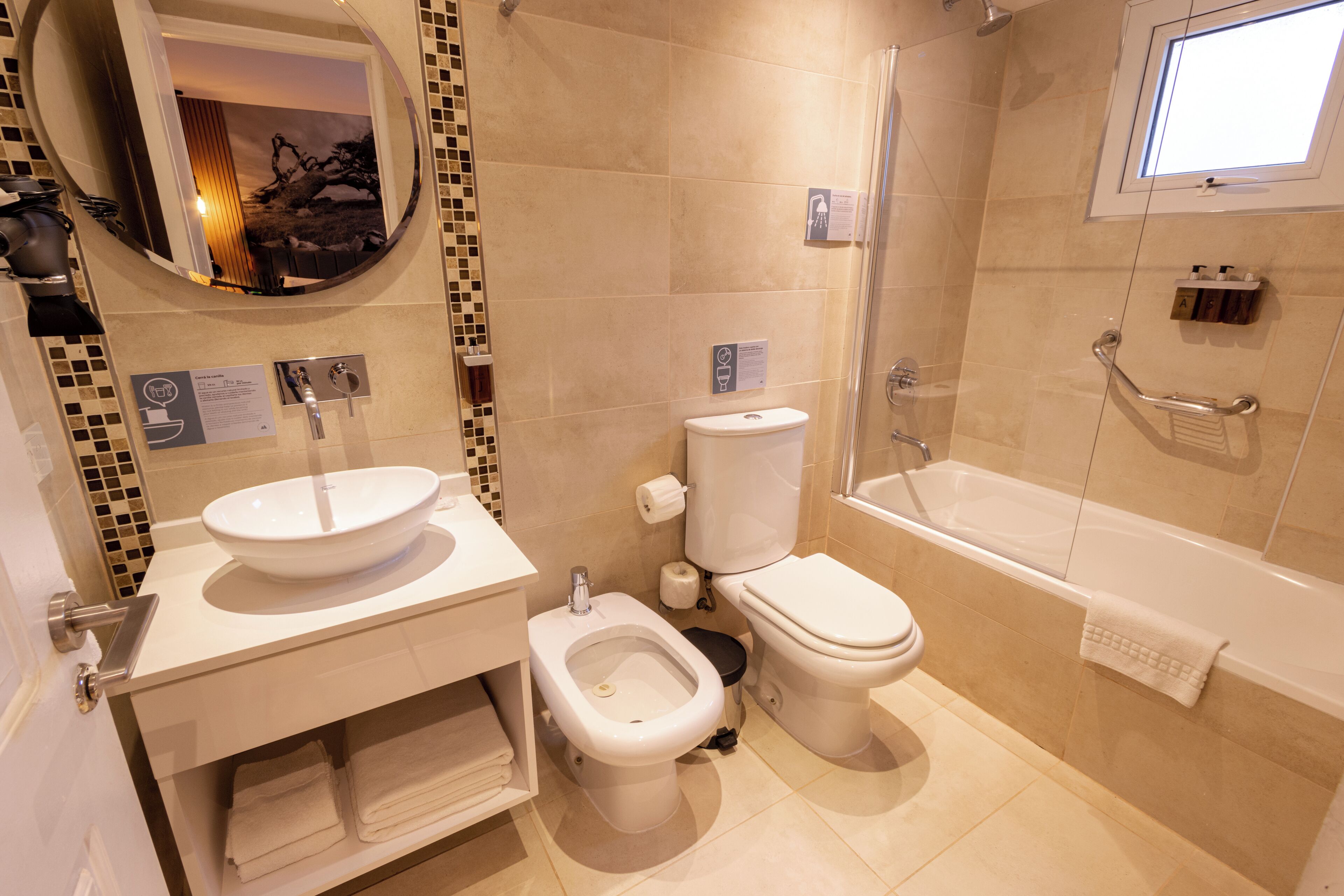 A modern bathroom with a sink, bidet, toilet, and bathtub.