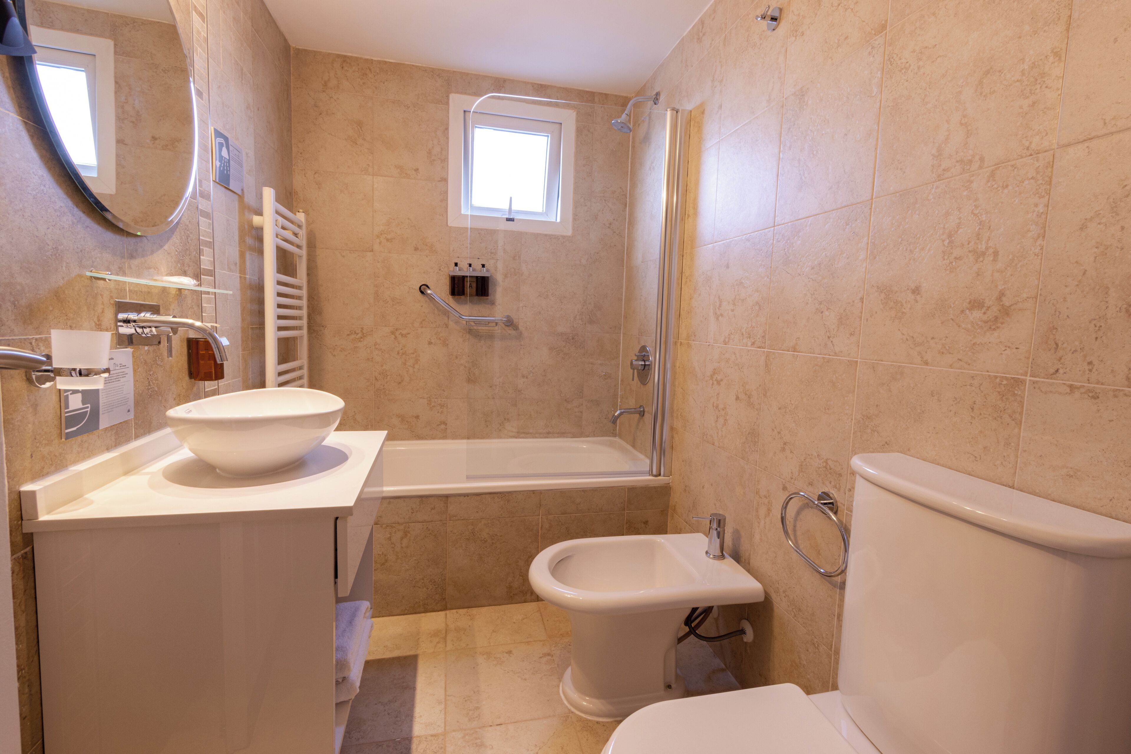 A bathroom with a bathtub, bidet, and toilet.