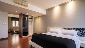 Un dormitorio moderno con una cama grande, un vestidor y vistas a un salón.