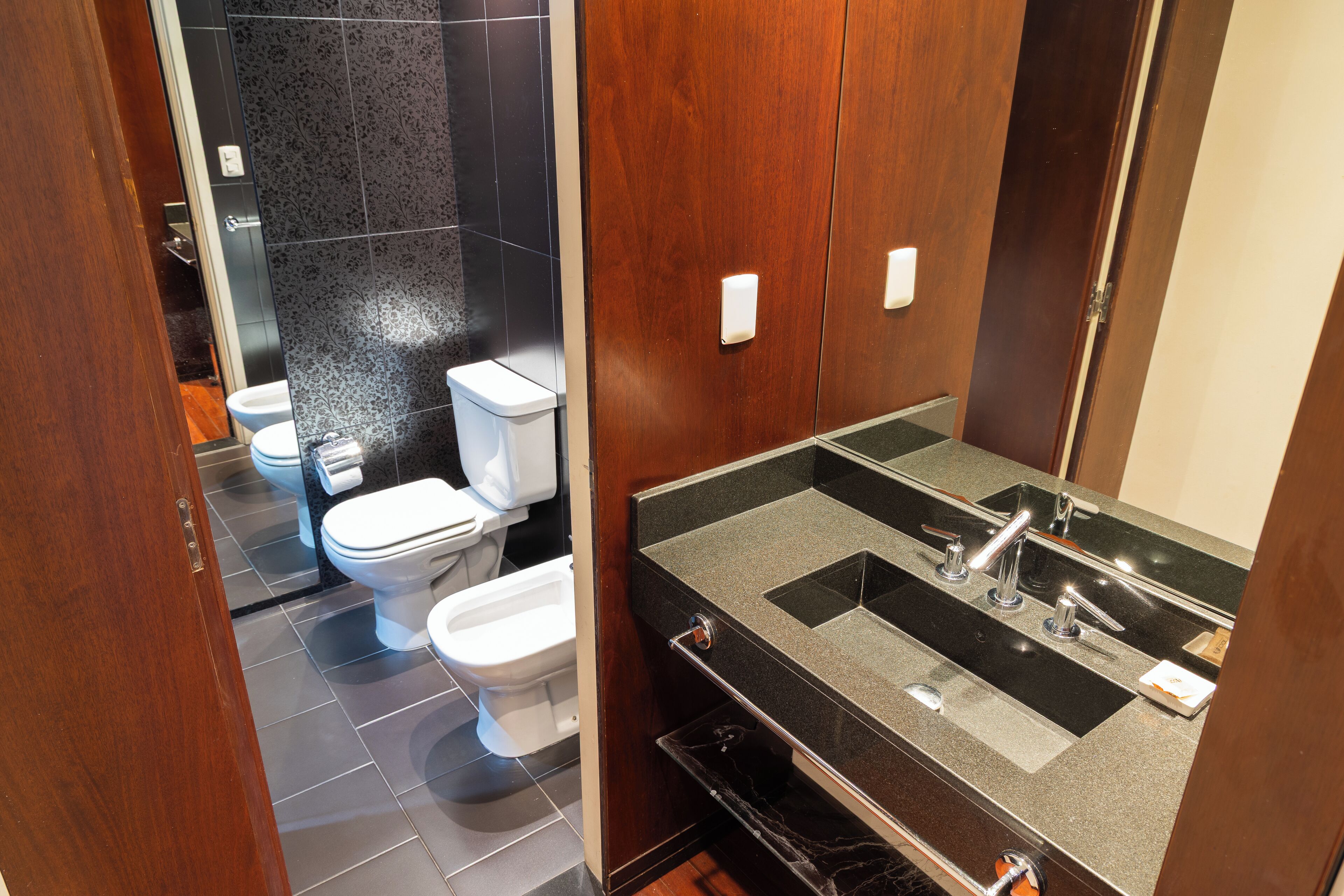 A modern bathroom with a wooden vanity, a sink, and a mirror.