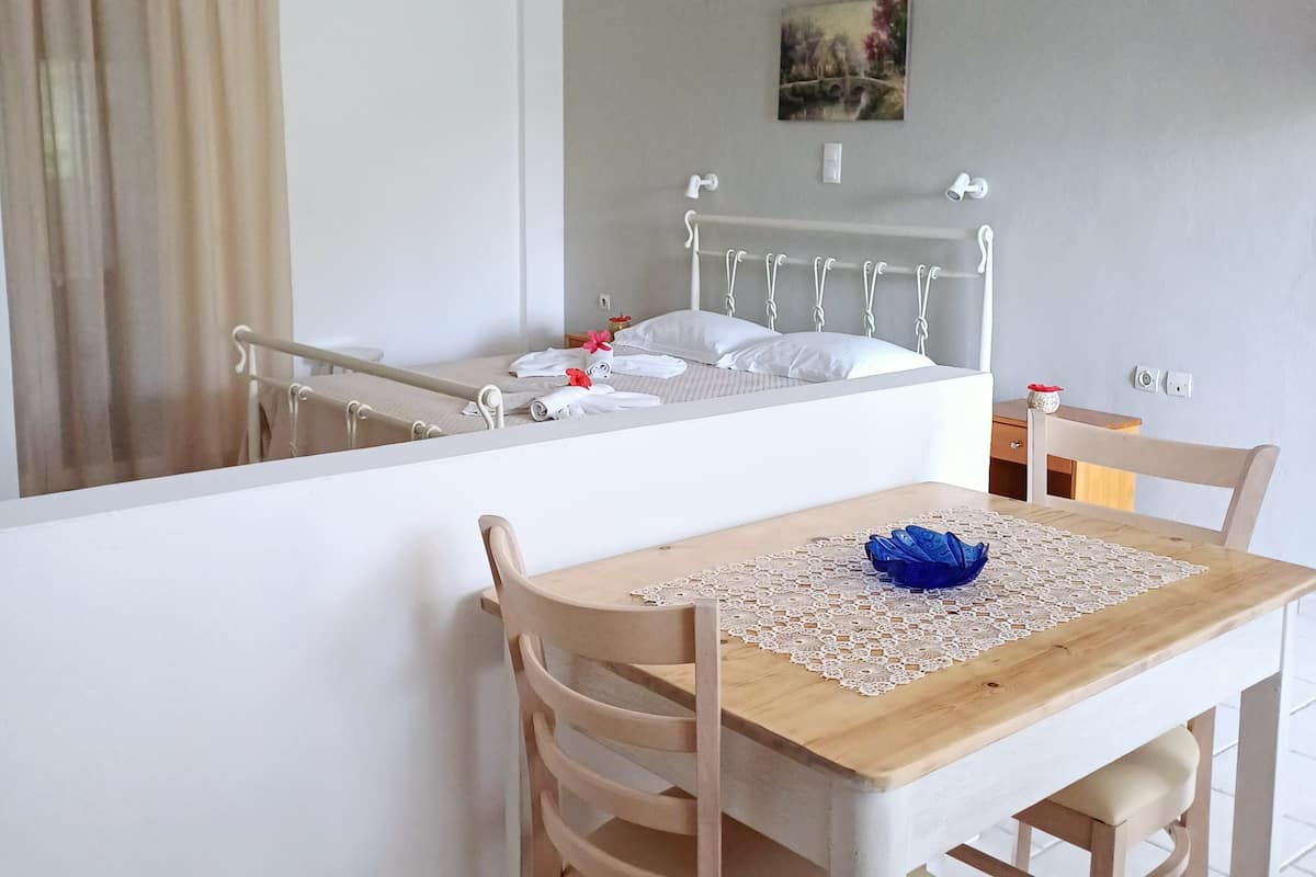 Un dormitorio con cama, mesita de noche y un cuadro en la pared.