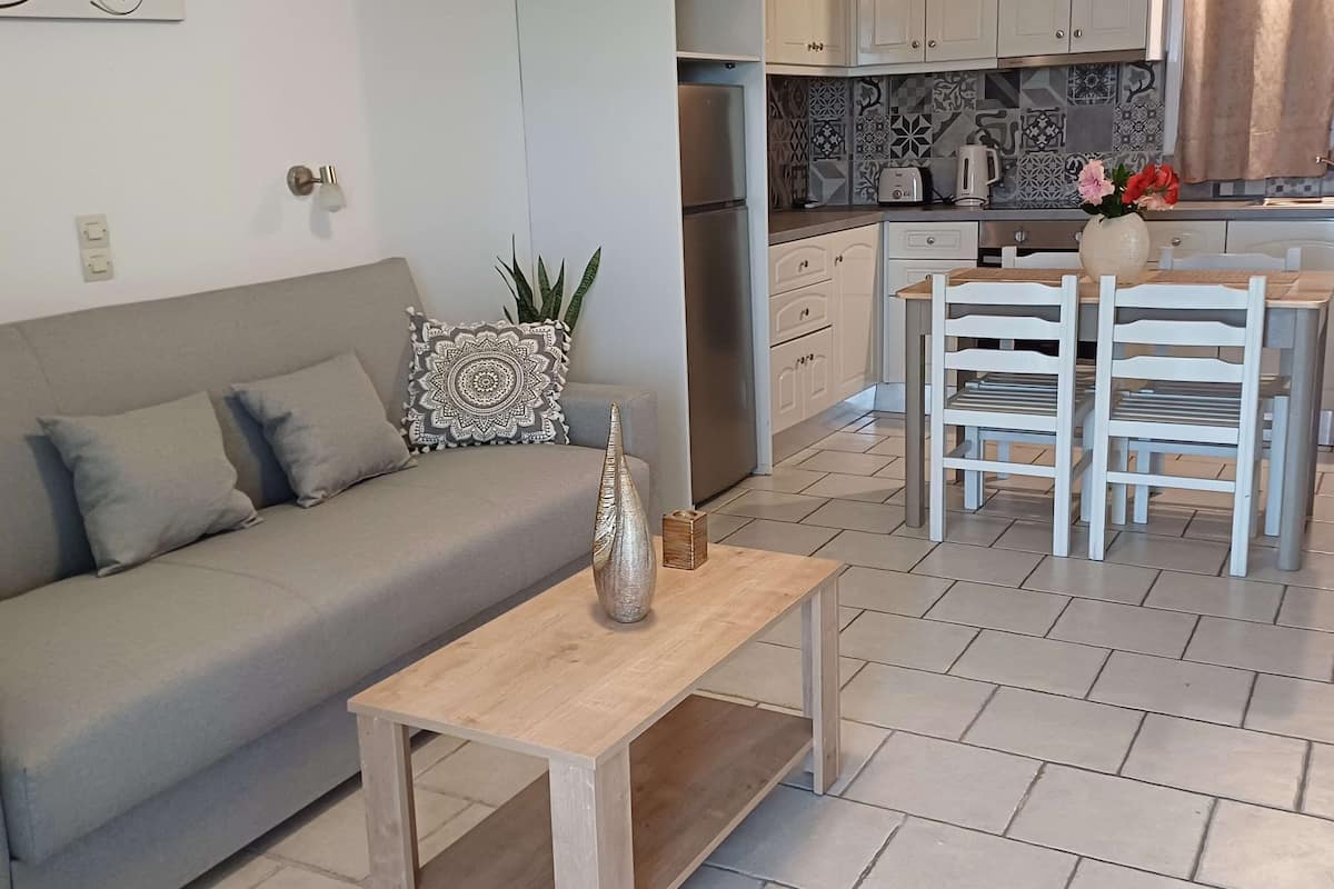 Una sala de estar moderna con un sofá, una mesa de centro y un comedor con sillas y una mesa.