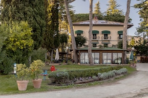 Un edificio con techo verde, amplios ventanales y un jardín con plantas en macetas.