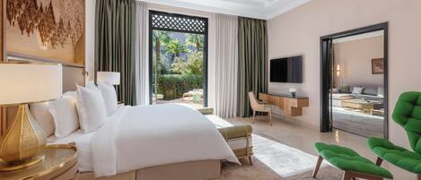 Een moderne hotelkamer met een groot bed, een bureau, een groene stoel en een televisie.