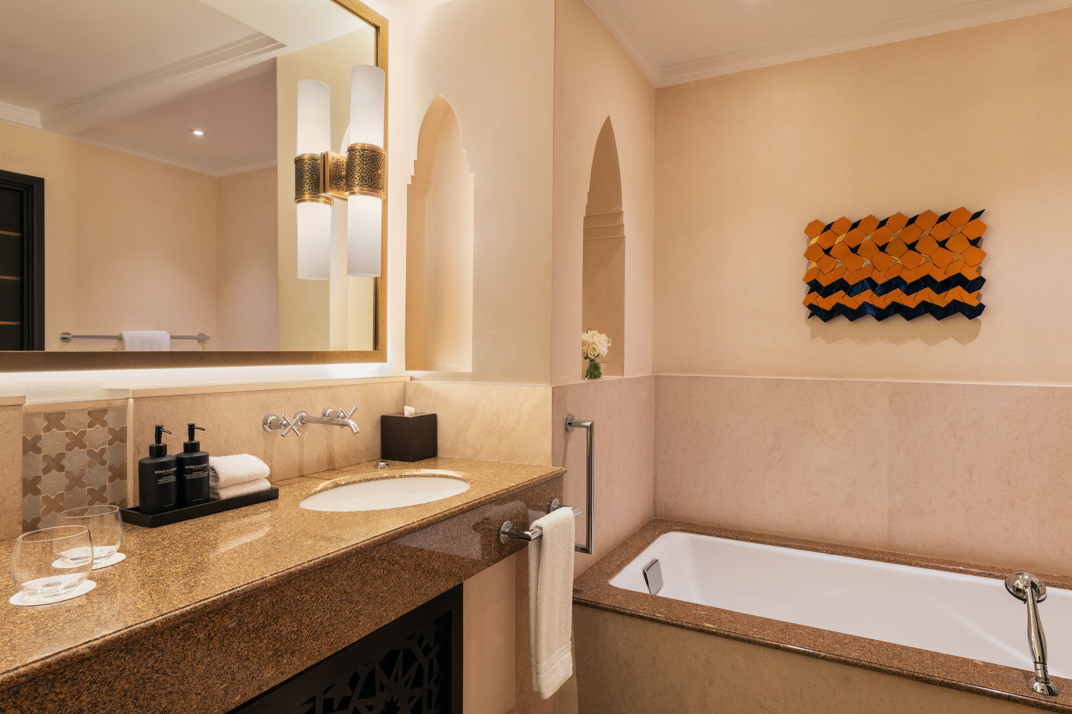 A modern bathroom with two sinks, a large mirror, and a bathtub.