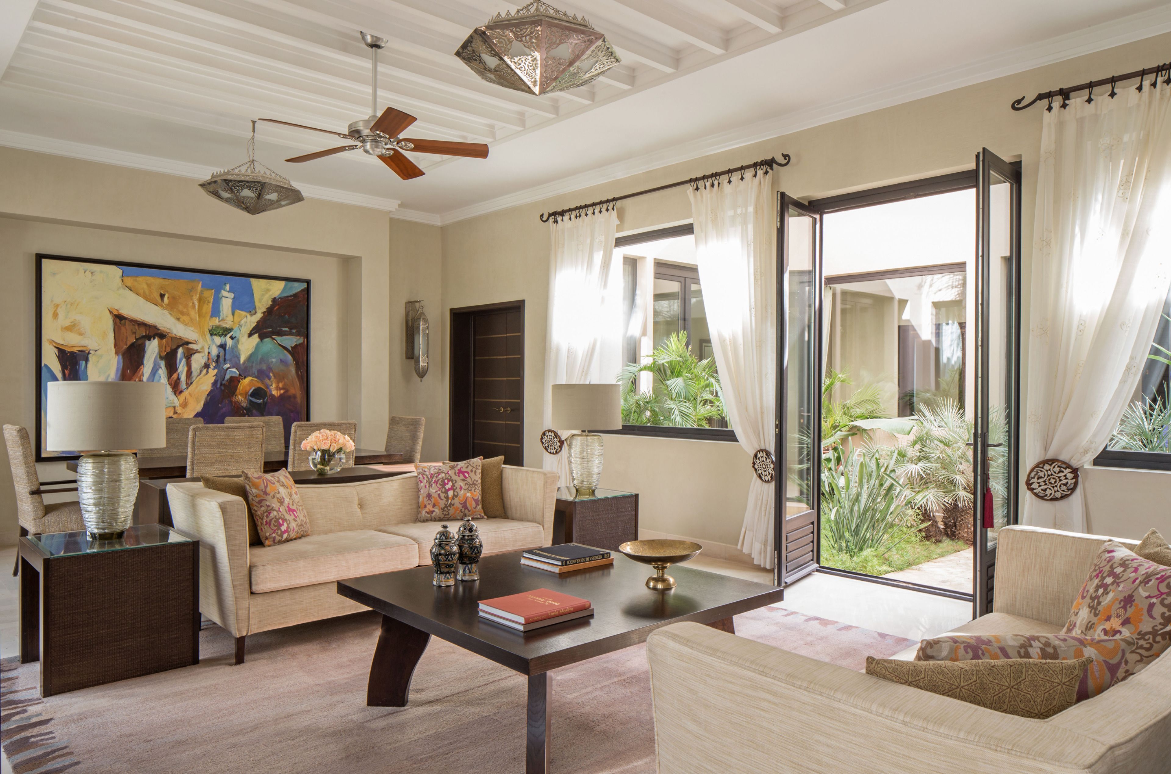 A spacious living room with a sofa, coffee table, and a painting on the wall.
