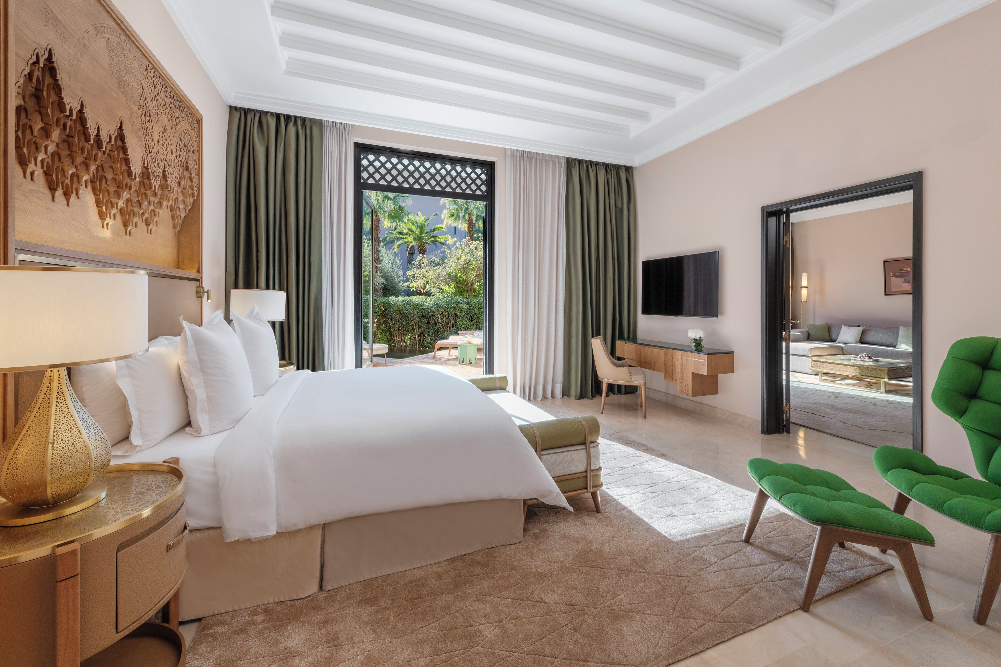 Una camera d'hotel con un letto, una scrivania, una sedia, una televisione e vista sull'esterno.