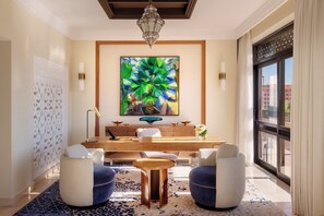 A modern hotel lobby with a large abstract painting, a wooden reception desk, and comfortable seating.