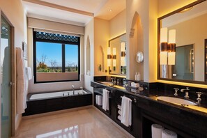A modern bathroom with dual sinks, a large mirror, and a window with a view of trees and mountains.