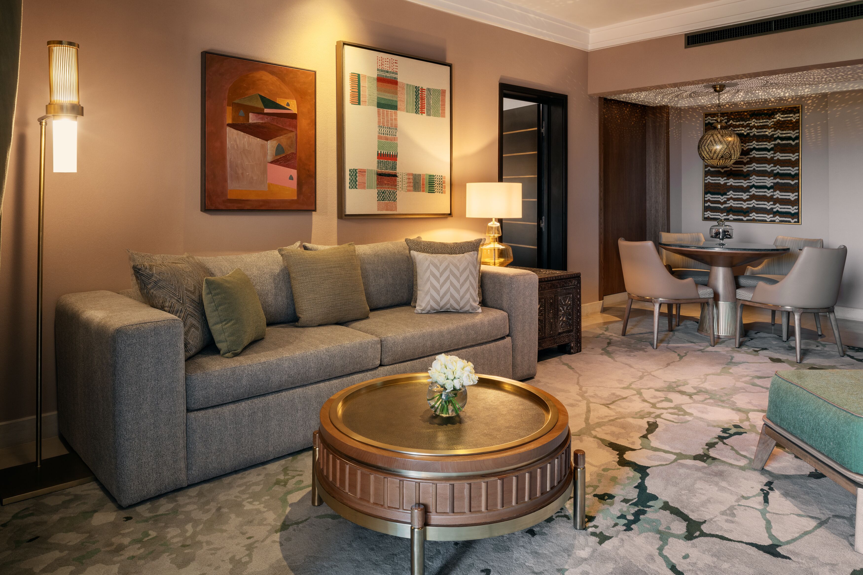 A modern living room with a sofa, coffee table, and dining area.