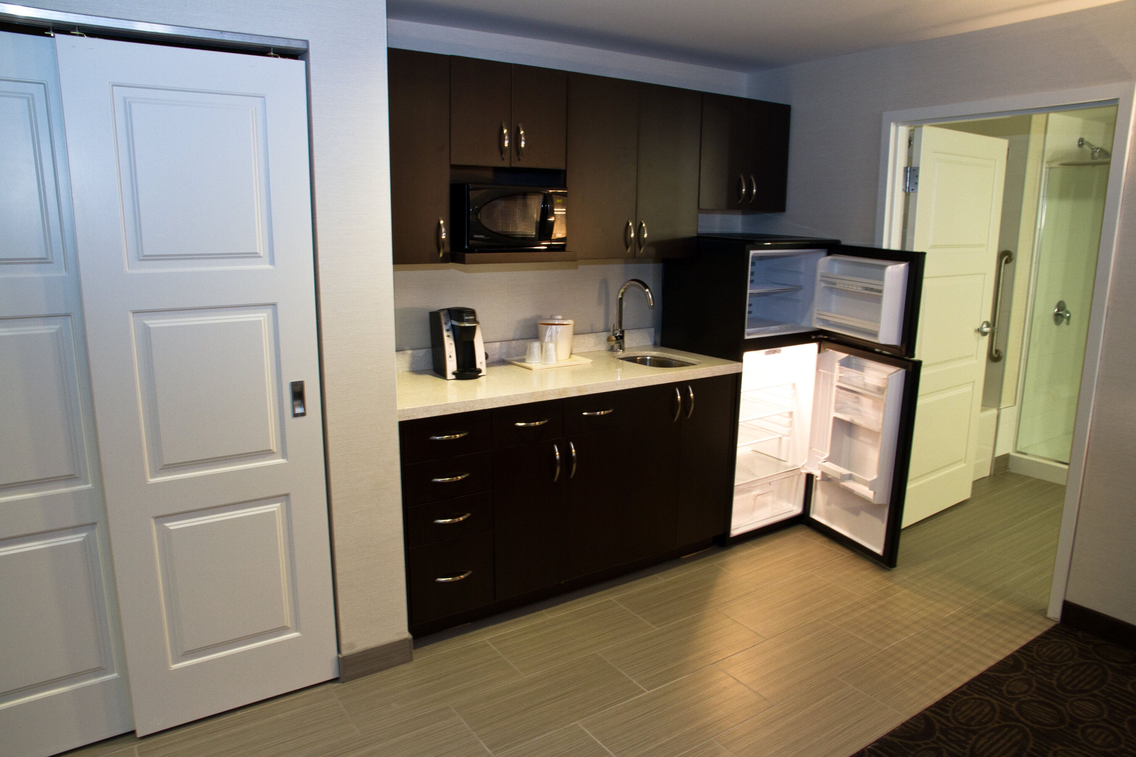 A compact kitchen with a refrigerator, microwave, and coffee maker.