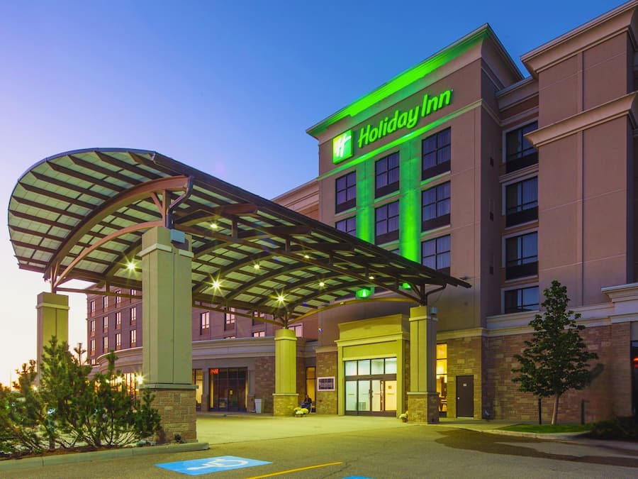 A Holiday Inn hotel with a covered entrance, multiple floors, and a brick facade.