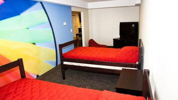A hotel room with two beds, a TV, and a desk.