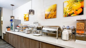 A breakfast bar with various food items and a coffee station. - Comfort Suites Oil Center (Lafayette)