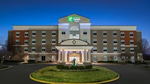 A Holiday Inn Express & Suites hotel with a central entrance, multiple floors, and a landscaped driveway. - Holiday Inn Express & Suites Terre Haute by IHG (Terre Haute)