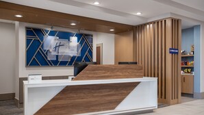 Una recepción de diseño moderno, una pared azul con motivos geométricos y un panel de madera.
