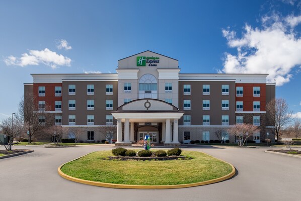 A large, multi-story hotel with a central entrance, surrounded by a well-maintained lawn and a parking area. - Holiday Inn Express & Suites Terre Haute by IHG (Terre Haute)