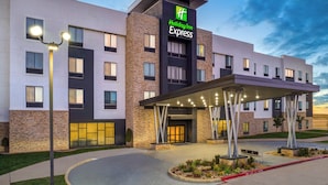 Edificio de Holiday Inn Express con un diseño moderno, que presenta una entrada destacada y un área exterior cubierta.