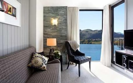A modern room with a sofa, a chair, a lamp, and a television.