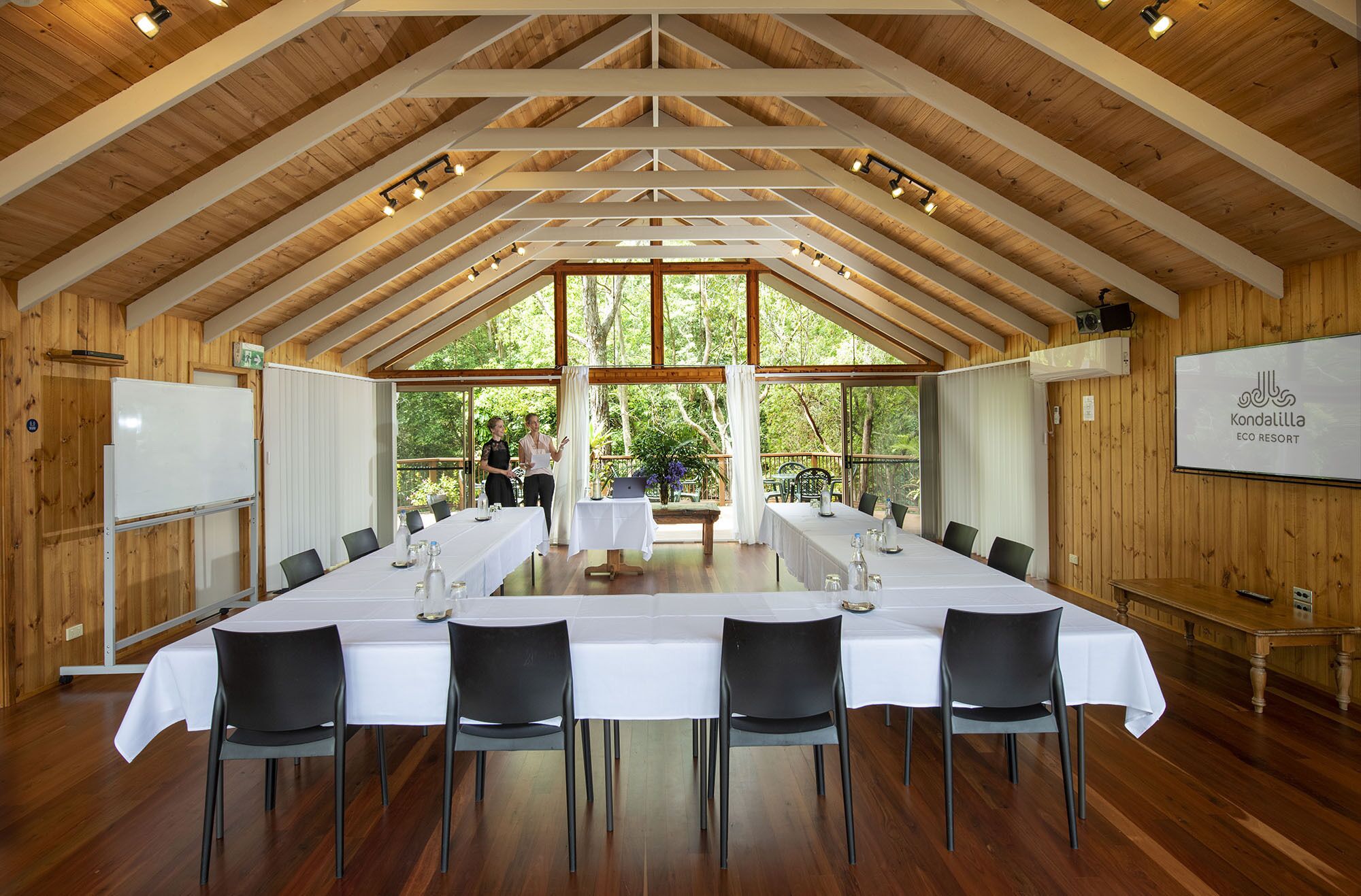 A conference room with a long table, chairs, and a whiteboard.