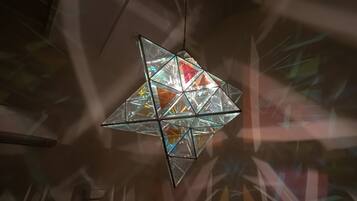 A geometric chandelier with multiple glass panels and a central light source.