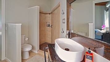 A bathroom with a white sink, a mirror, and a shower area.