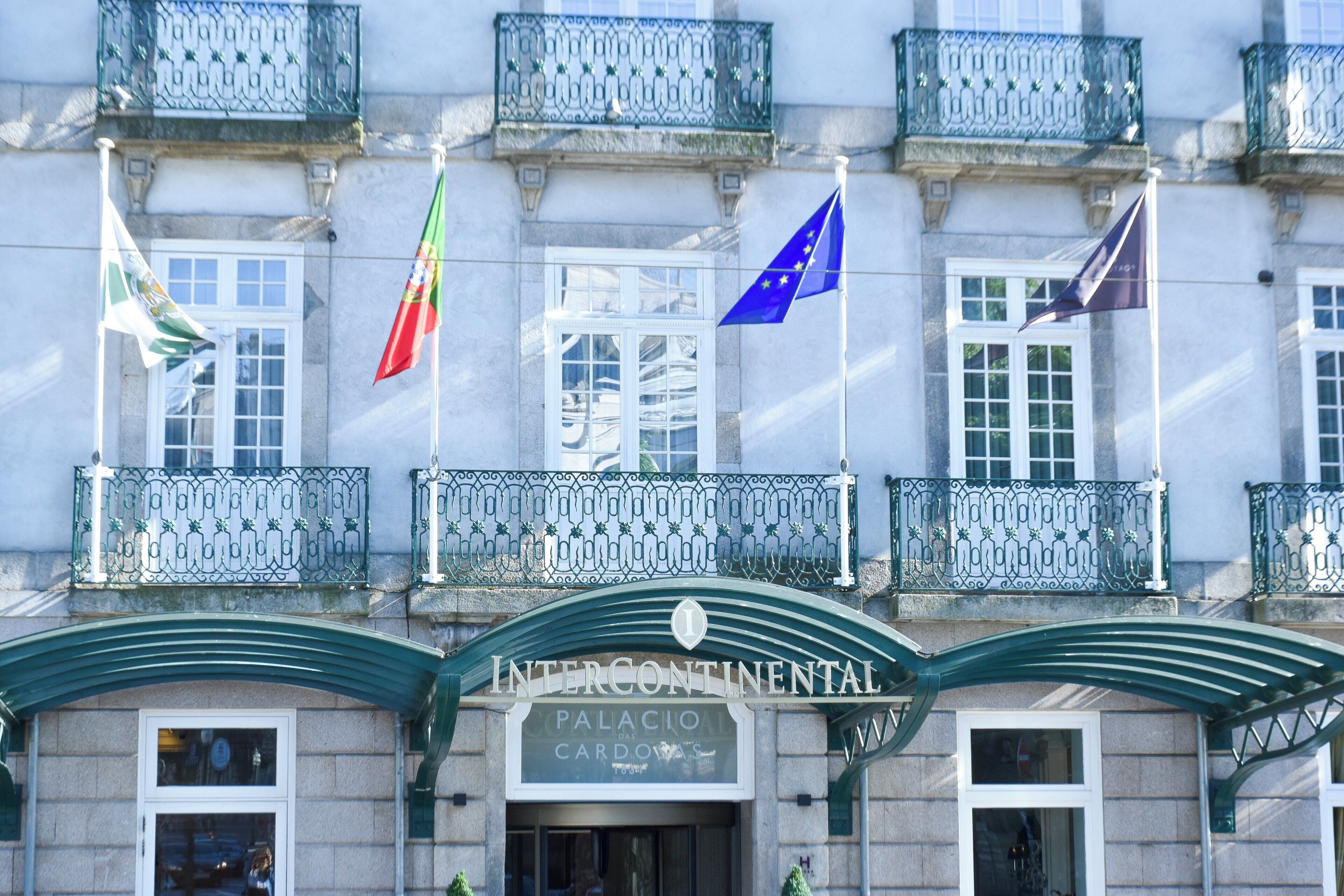 Un edificio con balcón, banderas y un cartel que dice 'INTERCONTINENTAL PALACE DAS CARDOS'.